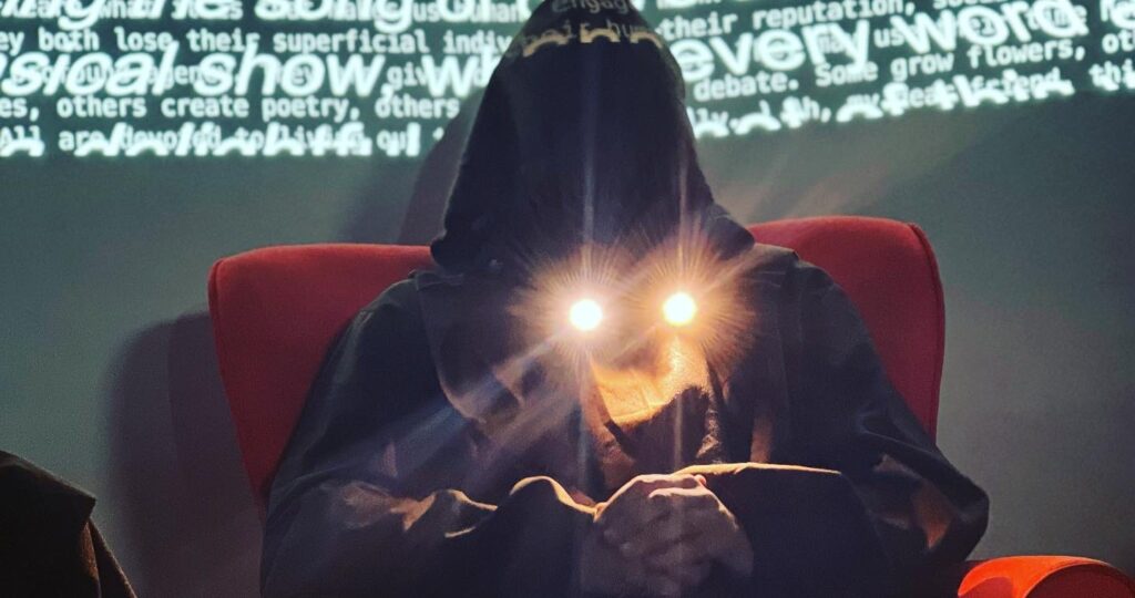 a monk sits with two lights coming from their neck