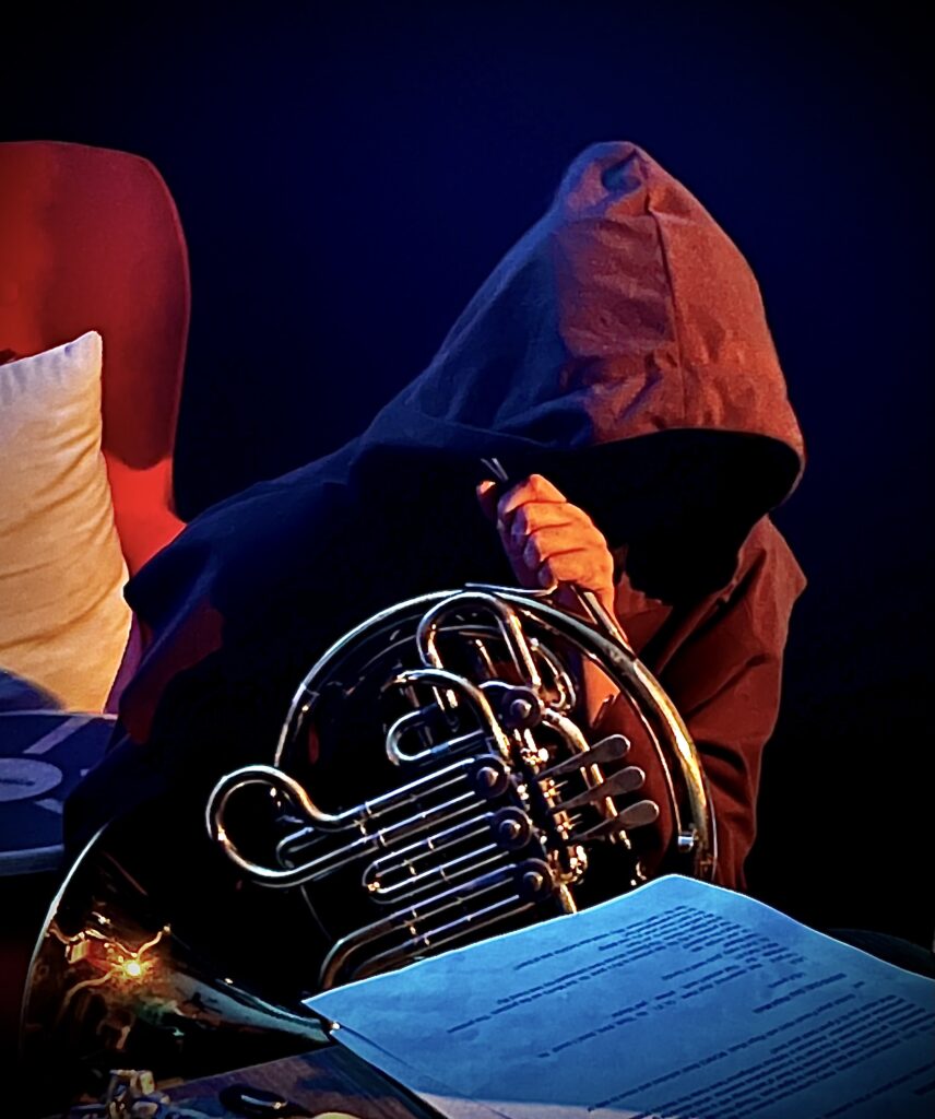 a monk holding a french horn.
